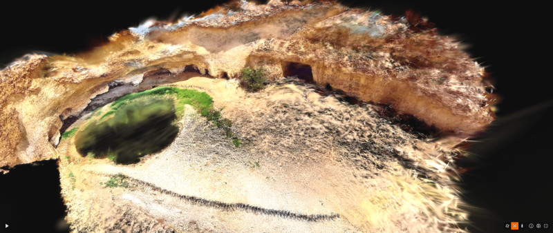 Desert waterhole with surrounding cliffs and caves